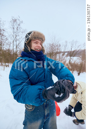 Young man laughing during winter outdoor game. 136130737