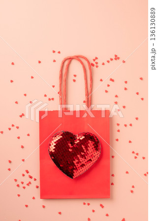 Red gift bag presenting sequin heart for valentine's day Red gift bag presenting sequin heart for valentine's day 136130889