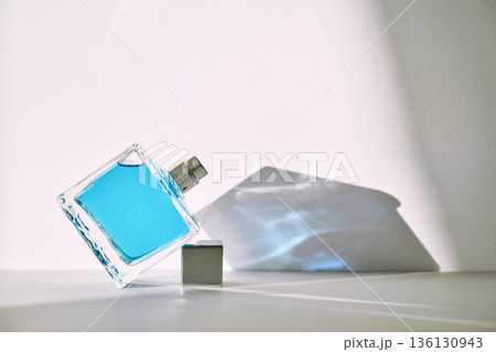 Blue fragrance bottle with abstract shadows and light 136130943