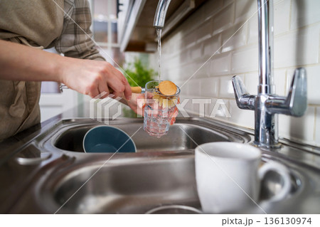 Zero waste concept. Eco-friendly kitchen wooden brush. Woman washing dishes with bamboo brush. Waste-free, eco-friendly concept 136130974