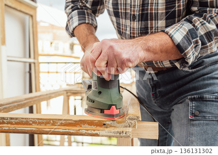 Carpenter at work, restoring an old wooden window. Carpentry. Carpenter at work, restoring an old wooden window. Carpentry. 136131302
