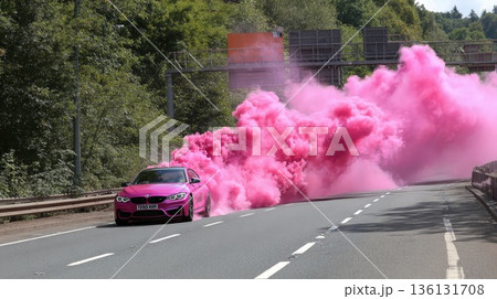 A glamorous pink car on the highway with pink smoke billowing out from underneath it A glamorous pink car on the highway with pink smoke billowing out from underneath it 136131708