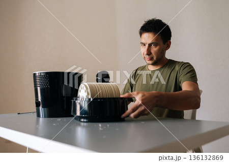 Portrait of professional technician brushing air humidifier filter, cleaning device components for improved indoor air quality, maintaining healthy living space. Concept of maintenance home appliance Portrait of professional technician brushing air humidifier filter, cleaning device components for improved indoor air quality, maintaining healthy living space. Concept of maintenance home appliance 136132869