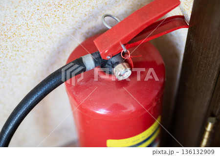 Wallmounted extinguisher with details. Industrial safety equipment showing wear and gauges Wallmounted extinguisher with details. Industrial safety equipment showing wear and gauges 136132909