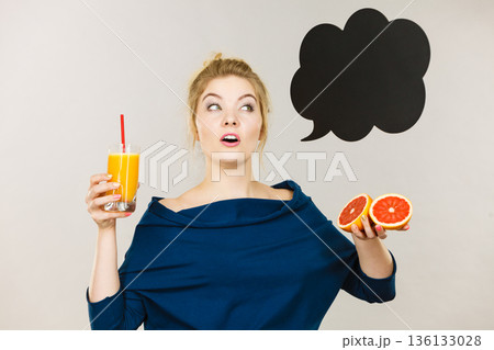 Happy woman holding fresh orange juice Happy woman holding fresh orange juice 136133028