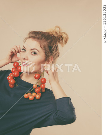 Woman holding fresh cherry tomatoes 136133035