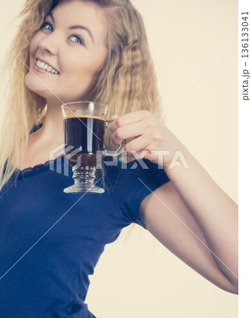 Positive woman drinking her morning coffee Positive woman drinking her morning coffee 136133041