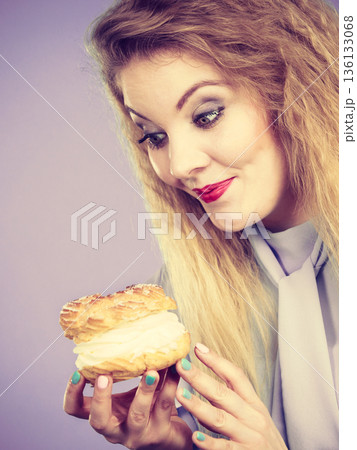Funny woman holds cream puff cake 136133068