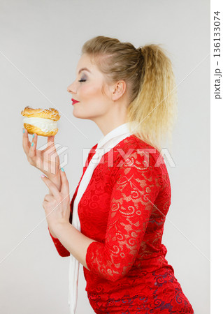 Happy woman holding choux puff cake 136133074