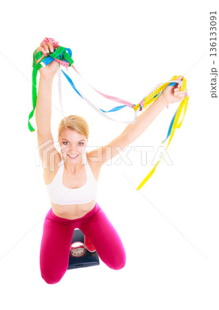 Joyful woman on weighing scale. Slimming diet. Joyful woman on weighing scale. Slimming diet. 136133091
