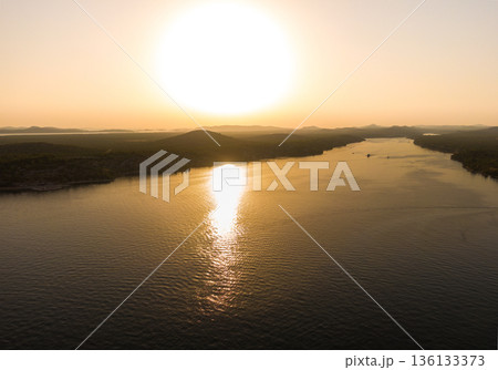 Aerial drone view of sunset over Kornati islands near the Sibenik city, Croatia. Water bay with boats ans soft sun light. Aerial drone view of sunset over Kornati islands near the Sibenik city, Croatia. Water bay with boats ans soft sun light. 136133373