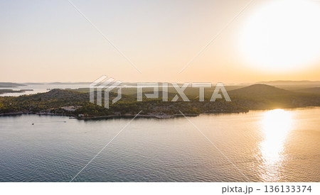 Aerial drone view of sunset over Kornati islands near the Sibenik city, Croatia. Water bay with boats ans soft sun light. Aerial drone view of sunset over Kornati islands near the Sibenik city, Croatia. Water bay with boats ans soft sun light. 136133374