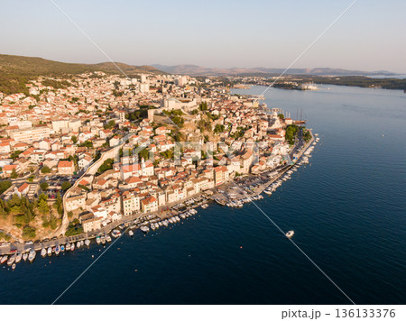 Aerial dronw view of sunset over the Sibenik city, Croatia. Ancient and old town coastline with harbor near the sea. Fortress above the city. Famous tourist destination in Croatia. Aerial dronw view of sunset over the Sibenik city, Croatia. Ancient and old town coastline with harbor near the sea. Fortress above the city. Famous tourist destination in Croatia. 136133376
