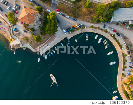 Top down aerial drone view to Sibenik city harbor, croatia. Sea water with boats and yacht. Walking path near the sea. Top down aerial drone view to Sibenik city harbor, croatia. Sea water with boats and yacht. Walking path near the sea. 136133379