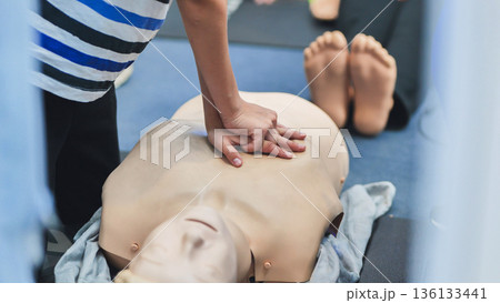 Hands performing chest compressions on a medical training mannequin for life saving skills Hands performing chest compressions on a medical training mannequin for life saving skills 136133441