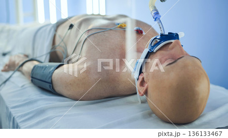 Intubated patient in intensive care unit receiving life support treatment 136133467