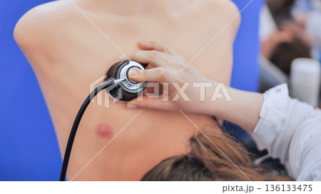 Student doctor using a stethoscope on a medical training mannequin practicing skills Student doctor using a stethoscope on a medical training mannequin practicing skills 136133475