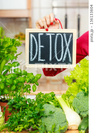 Woman having green diet vegetables, detox sign 136133604