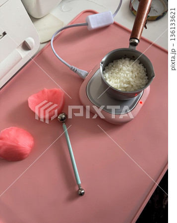 Ladle with beeswax. For candle making. Standing on a melting slab. 136133621