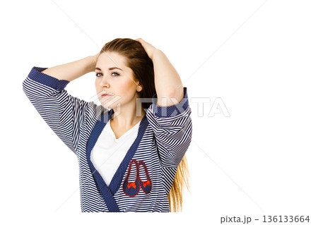 Young woman touching her long brown hair Young woman touching her long brown hair 136133664