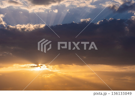The sunset over the clouds. Warm colors, light flares from the sun. The sunset over the clouds. Warm colors, light flares from the sun. 136133849