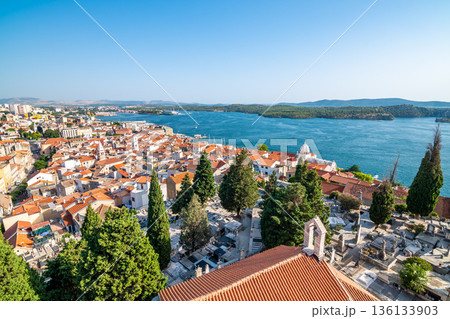 Coastal view of Sibenik old city, Croatia. Cathedral of St James, adriatic sea with island in background. Summer weather, aerial view of city roofs. UNESCO heritage. 136133903