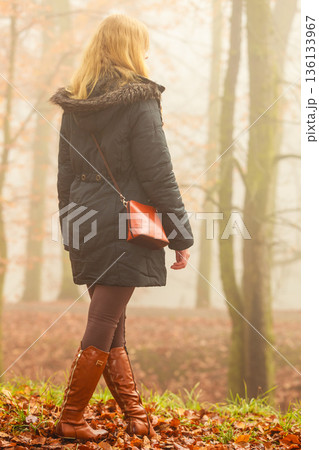 Woman walking in park in foggy day 136133967