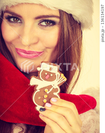 Woman santa claus hat with gingerbread cookie. Christmas 136134197