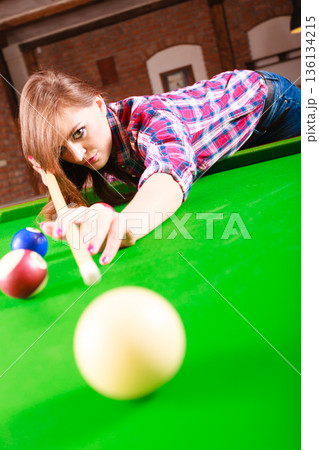 Young woman playing billiard. Young woman playing billiard. 136134215