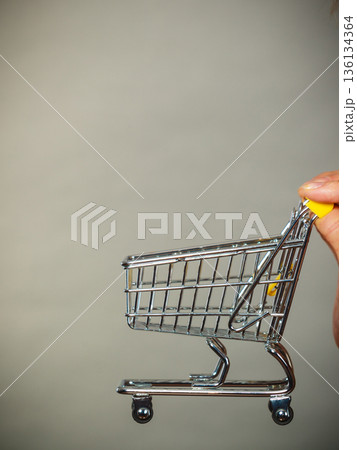 Woman hand holding small tiny shopping cart Woman hand holding small tiny shopping cart 136134364
