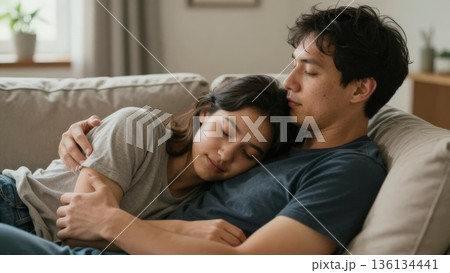 Asian Couple Cuddled On Sofa After Movie Night, Woman Asleep On PartnerS Arm, Soft Smiles, Low Warm Lighting, Casual Tees And Denim, Comfortable Domestic Scene Of Companionship And Calm Asian Couple Cuddled On Sofa After Movie Night, Woman Asleep On PartnerS Arm, Soft Smiles, Low Warm Lighting, Casual Tees And Denim, Comfortable Domestic Scene Of Companionship And Calm 136134441