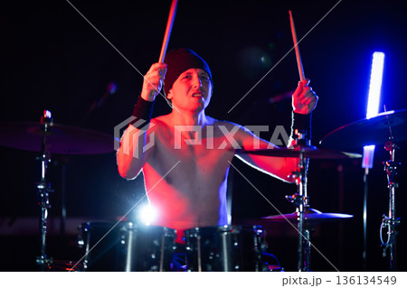 Drummer performing with passion on stage lights Drummer performing with passion on stage lights 136134549