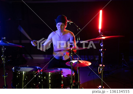 Drummer playing live music on dark stage Drummer playing live music on dark stage 136134555