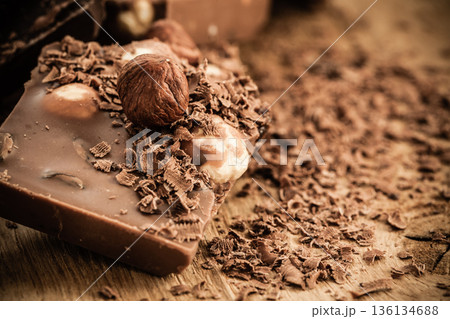 chocolate shavings and pieces on wooden table chocolate shavings and pieces on wooden table 136134688