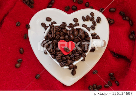 Heart shaped cup with coffee beans on red 136134697