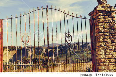 Old gate and Ronda town in distance, Spain. 136134955