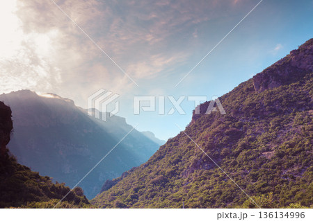 Mountain cliffs against sky with clouds Mountain cliffs against sky with clouds 136134996