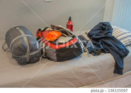Bedroom of young person, preparing his backpack for camping 136135097