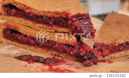 Berry pie slices showing fruit filling on parchment 136135192