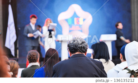 Audience at a global summit, focusing on speakers on stage with a BRICS logo Audience at a global summit, focusing on speakers on stage with a BRICS logo 136135212