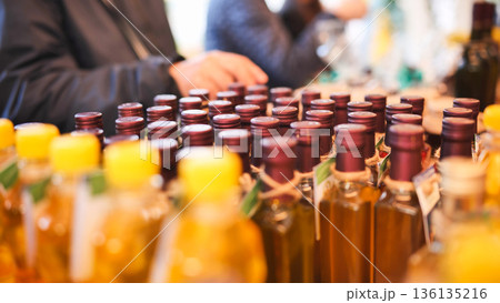Olive oil bottles on display at an Italian market for tasting and sale 136135216