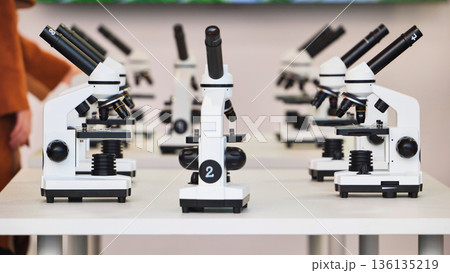 Microscopes lined up in a science laboratory classroom 136135219