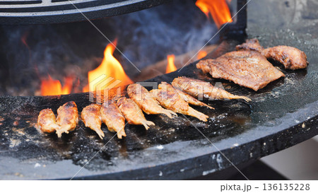 Grilling meat and fish on outdoor plancha with fire 136135228