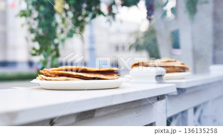 Golden pancakes on a white plate ready for street food serving or a casual breakfast. 136135258