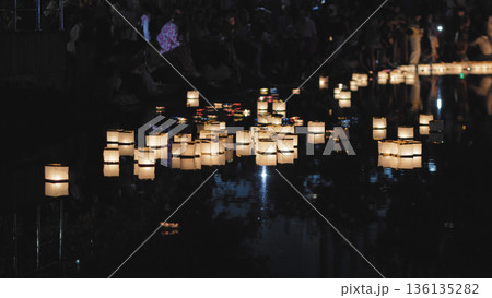 Square paper lantern floating on dark water at night Square paper lantern floating on dark water at night 136135282