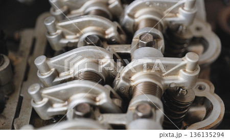 Car engine valve train during repair, showing rocker arms and cylinder head components Car engine valve train during repair, showing rocker arms and cylinder head components 136135294