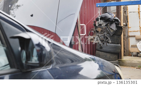 Car engine hanging in repair workshop with hood open Car engine hanging in repair workshop with hood open 136135301