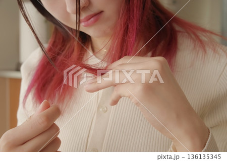 傷んだ髪の毛を気にする若い女性 傷んだ髪の毛を気にする若い女性 136135345