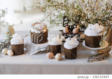 Easter cakes and painted eggs on spring table with blossom branches Easter cakes and painted eggs on spring table with blossom branches 136135847