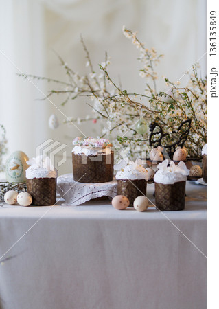 Easter cakes and painted eggs on spring table with blossom branches 136135849